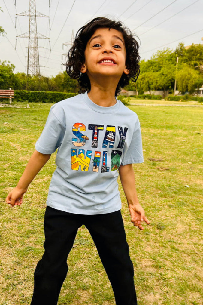 Child wearing a 'Stay Wild' t-shirt in a bright ash blue color